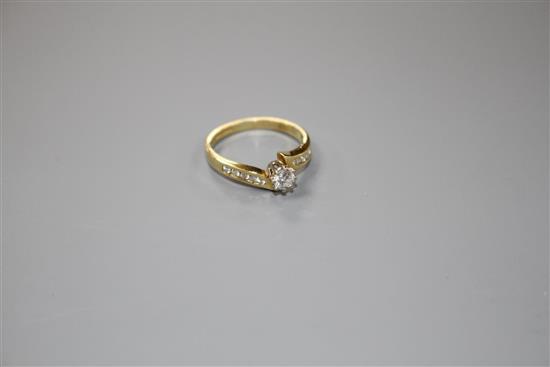 A modern 18ct gold and single stone diamond ring, with diamond set shoulders, size L/M, gross weight 3 grams.